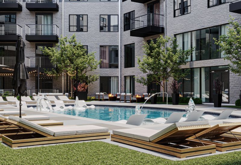 Modern apartment courtyard with a pool, lounge chairs, umbrellas, and trees surrounded by buildings.