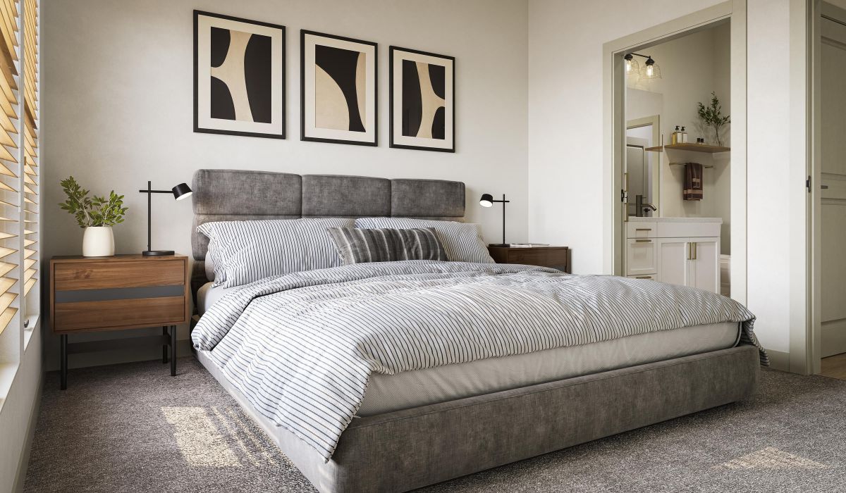 Modern bedroom with a gray bed, striped bedding, abstract wall art, and a view into a bright bathroom.