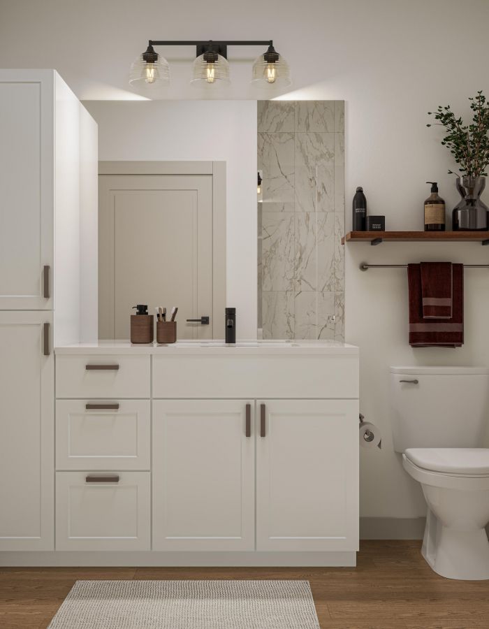 Modern bathroom with white cabinetry, a toilet, shelf with decor, and a large mirror above the sink.