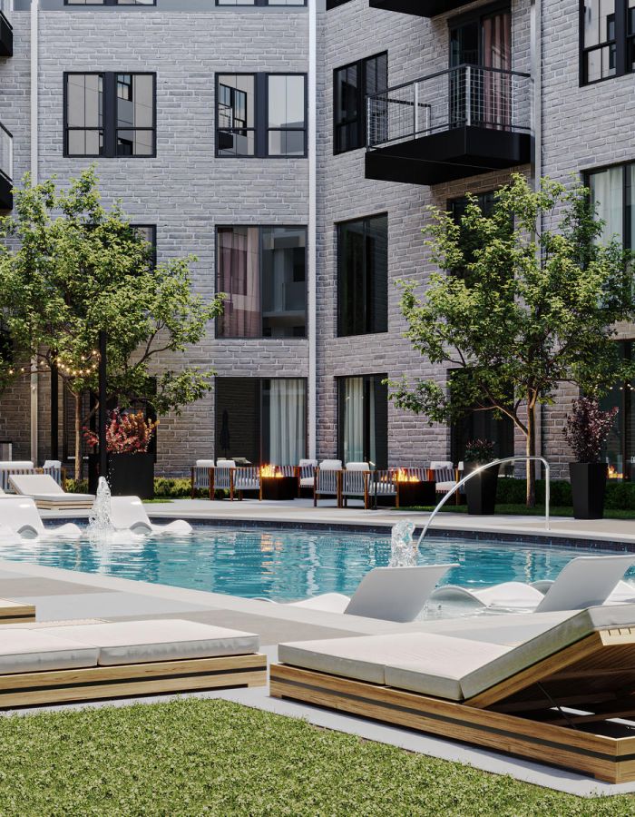 Modern apartment courtyard with a pool, lounge chairs, umbrellas, and trees surrounded by buildings.